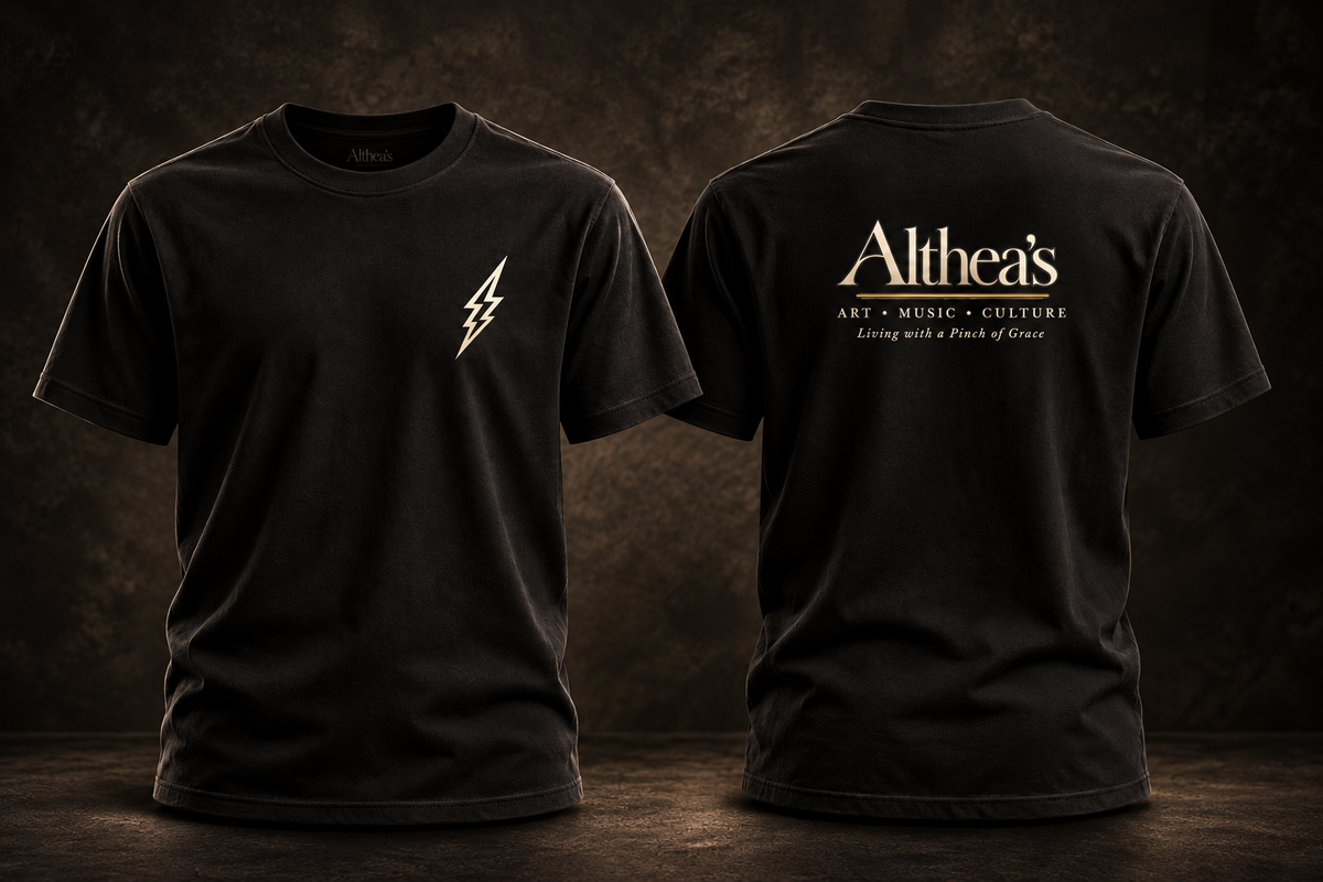 Front small ivory lightning bolt, back modestly sized full Althea's logo; black shirt on dark studio background